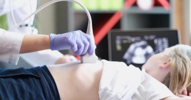 Doktor, klinikte tarayıcı kullanan bir kız için karın ultrasonu yapar. İç organ konseptinin teşhisi