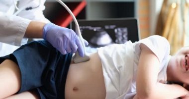 Ultrason cihazı kullanan küçük bir kızın tıbbi muayenesi. Sonograf çocuk karnındaki ve böbreklerindeki güç çeviriciyi hareket ettiriyor. Profesyonel klinik tanılama ve tedavi