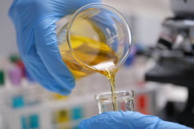 Kimyasalları karıştırıp döküyorum. Laboratuvar ve bilimsel deneyler. Tıbbi araştırmalar için kimyasalların petrol formülü.