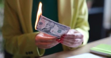 Kadın on dolarlık banknotu yakıyor. Para yakma kavramı