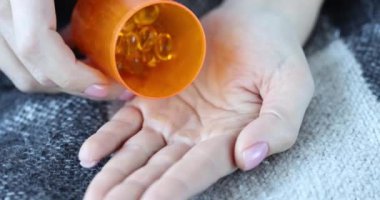 Balık yağı haplı kadın avuç içlerine doluyor. Keten tohumu yağı veya omega 3 sağlık kapsülleri