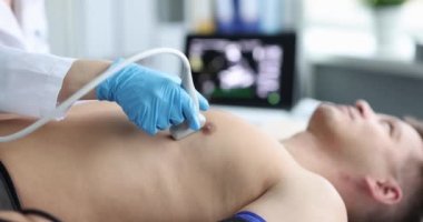 Doktor, erkek göğsünde ultrason makinesi tutuyor. Hastane odasındaki hastanın kalbini kontrol ediyorum.