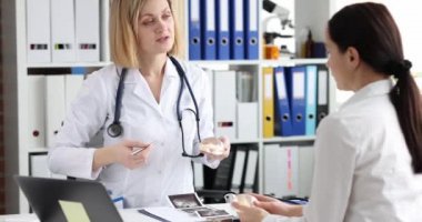 Klinikteki hastaya silikon göğüs büyütme implantı gösteren bir doktor. Estetik cerrahi konsepti