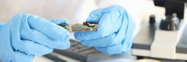 Laboratuvarda yakın planda lastik eldivenlerde mikroçip tutan bilim adamları. Yeni elektronik teknoloji kavramının icadı