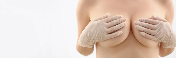 Close-up of womans body without clothes, cover breasts with hands, natural size of boobs. Womans decision to enlarge breasts, beauty procedure. Plastic, cosmetic surgery concept. White background