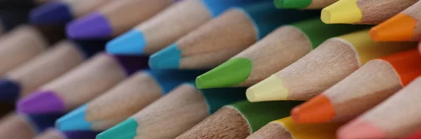 Close-up of sharpened pencils for drawing laying on each other forming repeated stack. Pigmented crayons for drawing. Vision, idea, imagination concept