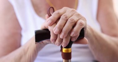 Yaşlı engelli büyükanne elinde baston tutuyor. Üzgün yaşlı bir kadın ve umutsuzca sağlık sorunları konsepti yüzünden depresyonda.