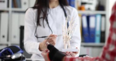 Klinikteki travmatologun resepsiyonunda elleri burkulmuş bir hasta. Sağlık sigortası veya uzuv yaralanması kavramı