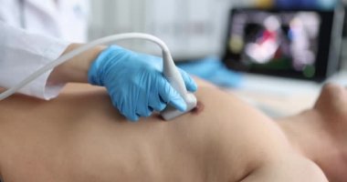 Doktor, erkek hastanın kalbini taramak için ultrason makinesi kullanıyor. Kardiyolog klinikte ve kardiyovasküler testlerde hasta ekokardiyografisi çalışması yapıyor..
