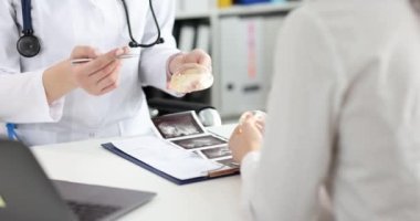 Doktorun ellerine silikon göğüs implantı. Beyaz önlüklü doktor hasta göğüs implantı konseptini gösteriyor.