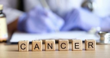 Doctor fills out medical paperwork and word cancer closeup. Diagnosis treatment drugs cancer concept