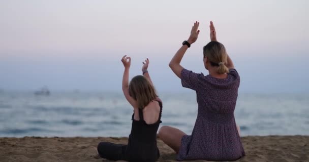 母亲和女儿在海滩上做瑜伽的轮廓 面向儿童和成人的家庭瑜伽概念 — 图库视频影像