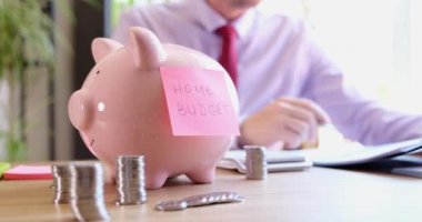 Man considers home budget and financial savings in piggy bank. Savings and investment family budget concept