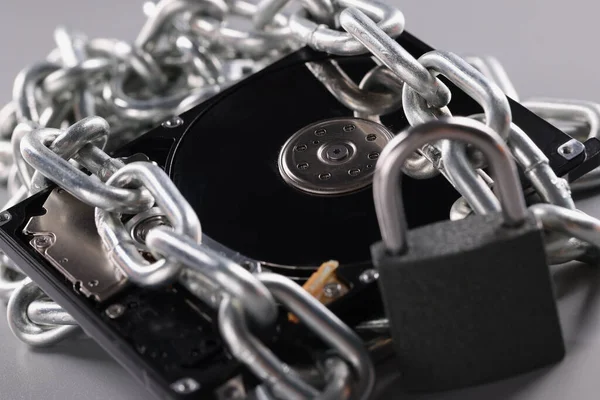 Computer hard drive is wrapped in chain. Password for hard drive concept