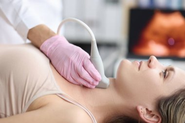 Klinikteki genç bir kadında tiroit bezinin ultrason teşhisi. Teşhis için klinikte muayene