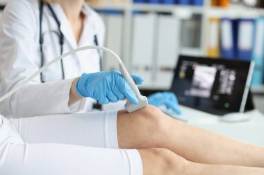 Ortopedi doktoru, klinikte hastanın dizini ultrasonla muayene ediyor. Tıbbi araştırma ve eklem iltihabı kavramı