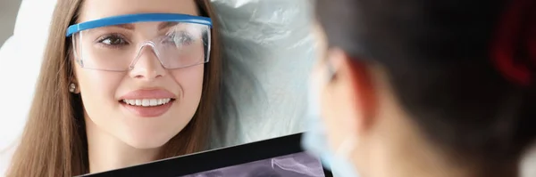 診療所における歯科診察時の患者の肖像 医師は デジタルタブレットデバイス上の歯X線を検査します 予約時の組織学者 歯のケアの概念 — ストック写真