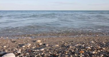 Güzel deniz dalgaları sahildeki kayalık sahile çarpar. Çakıl taşlı deniz sahili konsepti