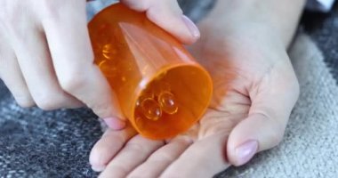 Dişi eller omega-3 kapsülleri döker. Balık yağı ve vitamin konseptinin faydaları