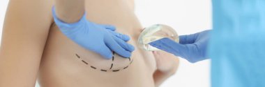 Silikon göğüs implantı ve avuçlayan müşteri göğsü. Kabinede üstsüz bir kadın. Cerrahi, güzellik, ilaç, plastik ameliyat konsepti