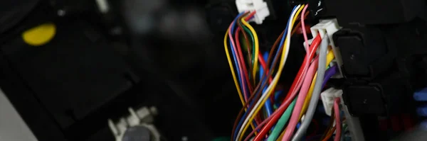Close-up of set of cables with multicolored wires and connectors in car. Electric connector plug put in car engine. Maintenance for automobile, fix concept