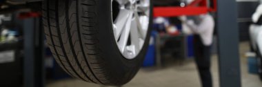 Yepyeni bir otomobil lastiğinin yakın çekimi, servis merkezinde aracın bir parçasını değiştirmek. Kış için kar lastiklerini değiştirmek için araba bakımına git. Pit stop konsepti