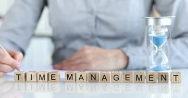 Zaman yönetimi ahşap küplere yakın plan, yüzeysel odaklanma üzerine yazılır. Kadın kalemle yazıyor. Verimli zaman kullanımı