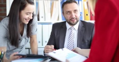 In the office, a man boss listens to women, close-up. Informal meeting at work, casual communication of employees