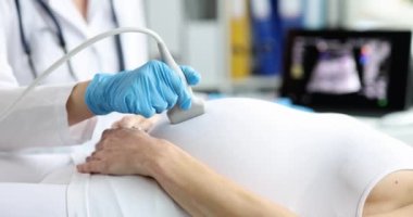 Doktor yakın plan hamile bir kadının ultrason taramasını yapar. Tıbbi ekipman, fetal sağlık teşhisi