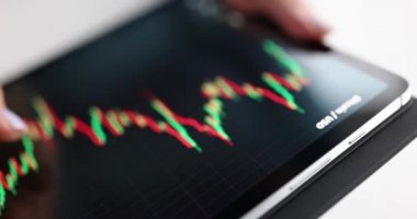 Kadın, dijital tablet kapanış filmi kullanarak hisse senetlerinde kripto döviz kurunun büyüme grafiğini inceliyor. Çevrimiçi kazançlar bitcoin konsepti satıyor