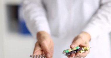 Doctor pharmacist holding lot of blister with pills and capsules 4k movie slow motion. Pharmaceutical business concept