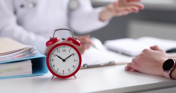 Red Alarm Clock Standing Table Doctor Patient Closeup Movie Slow — Wideo stockowe