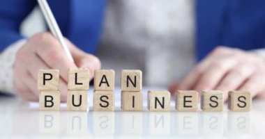 Bir iş adamının masasında tahta küpler, yakın plan, sığ odak. Şirket açıklaması