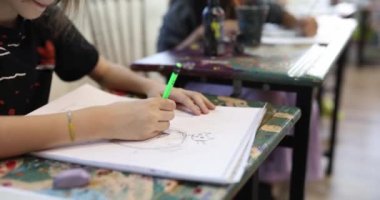 Çocuklar bir sanat okulunda masalarına resim çizerler, yakın plan. Klasik çizim eğitimi, yaratıcı beceriler