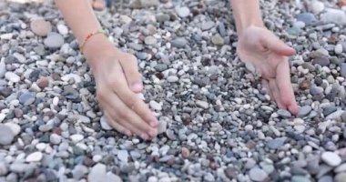 Çocukların elleri avuçlarında küçük çakıl taşları toplar, yakın plan. Pediatrik terapi, el manipülasyonu