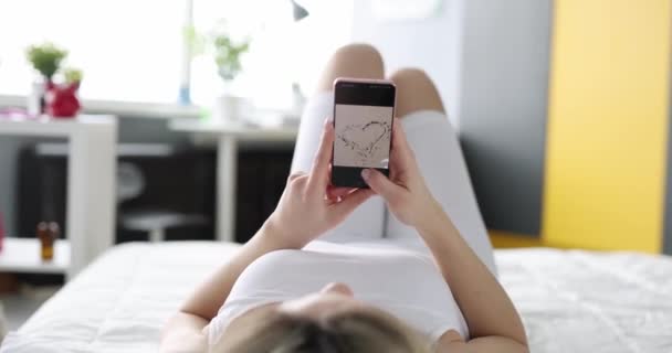Kobieta Leżąca Kanapie Przewraca Zdjęcie Ekranie Smartfona Zbliżenie Zdjęcia Osobiste — Wideo stockowe