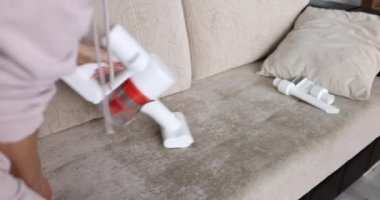 Güçlü kablosuz süpürge ve beyaz siklon toz toplama teknolojisi kanepeyi temizliyor. Döşeme mobilya temizleme konsepti