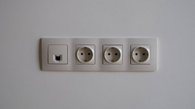 Beyaz duvarda elektrik prizi var. Yakın plan. Anten kablosu ve internet konsepti olan soketler