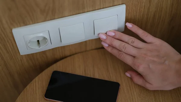 Woman Hand Presses Turn Lights Closeup Electric Socket Plug Smartphone — Fotografia de Stock