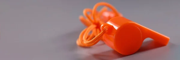 灰色背景上有绳子的橙色塑料哨子 体育配件吸引玩家注意力的概念 — 图库照片