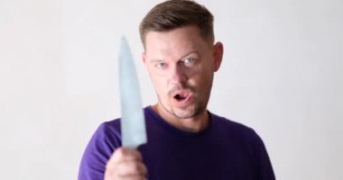 Young man dancing with kitchen knife in his hands 4k movie. Bipolar personality disorder concept