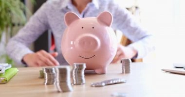 Business woman making roof from her hands over piggy bank with coins closeup 4k movie. Investment insurance concept