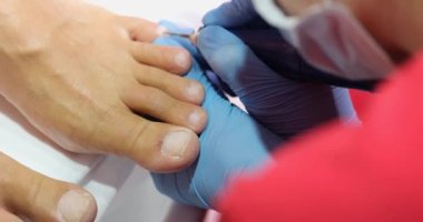 Podiatrist doing pedicure to client using grinding tool closeup 4k movie. Quality professional pedicure concept