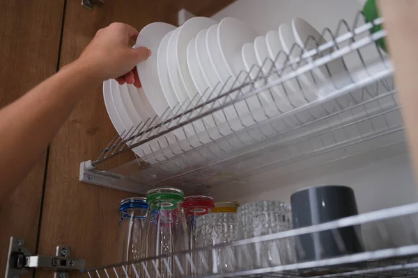 Woman Graceful Hand Takes Out Clean Plate Cupboard Dryer Dishes — Stockfoto