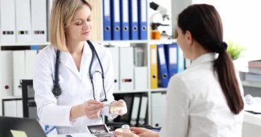 Mutlu kadın göğüs implantı olan bir estetik cerrahı dinliyor, yakın plan. Klinikte meme bakımı.