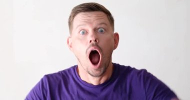 A man in shock, opened his mouth and grabbed his head, close-up. Emotions and bright facial expressions