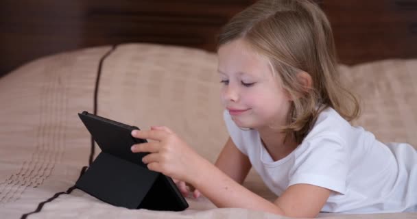 Small Girl Lying Sofa Looks Screen Tablet Close Home Schooling — Αρχείο Βίντεο