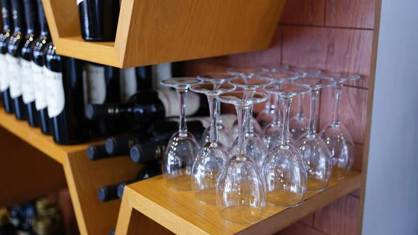 Bottles of wine wine glasses on cabinet rack. Selection of quality wine concept