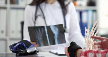 Doctor examined patient with pain in wrist and x-ray of hand. Wrist injury treatment sprain dislocation concept