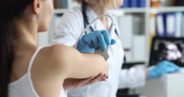 Medical device examines elbow joint of woman on medical ultrasound. Elbow pain causes and diagnosis concept